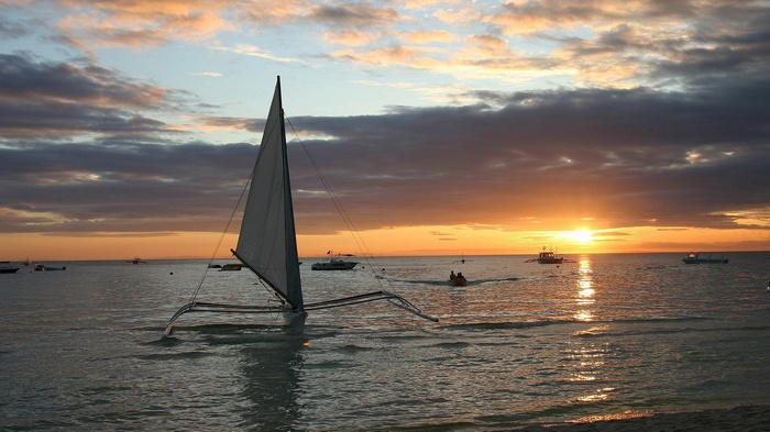 Sailboat on the ocean at sunset