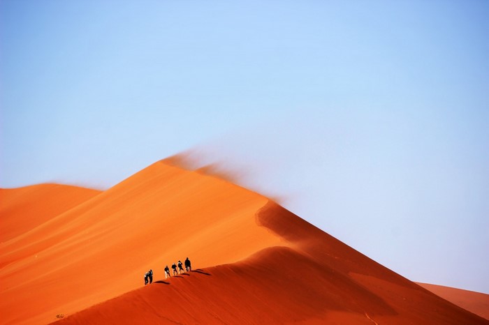 People walking on sand dunes in the desert
