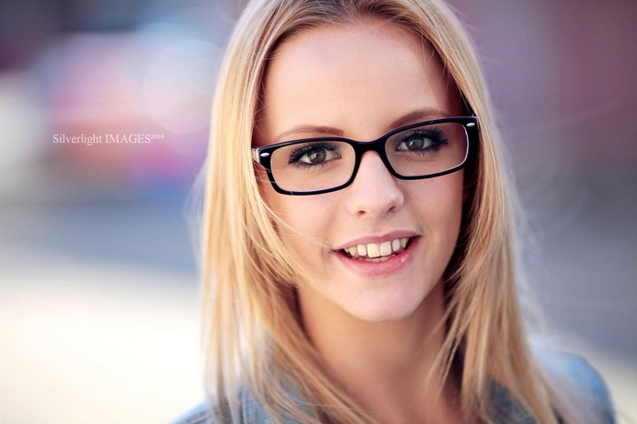 Woman with blonde hair and glasses smiling