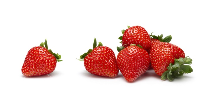 Several ripe strawberries on a white background