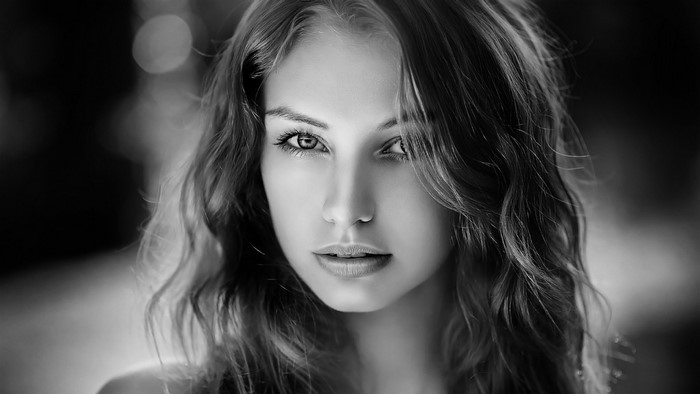 Monochrome portrait of a young woman with long wavy hair