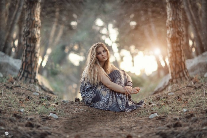 Woman sitting in a forest with sunlight