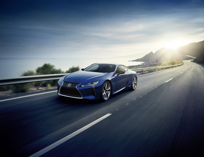 Blue Lexus LC 500h driving on a coastal road