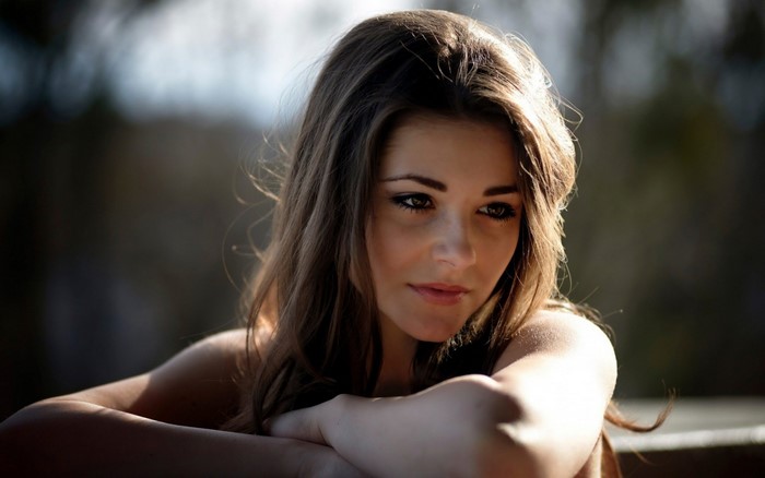 Pensive Woman with Long Brown Hair Outdoors