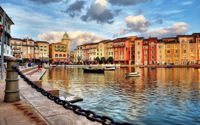 Colorful buildings along a canal with boats and chains