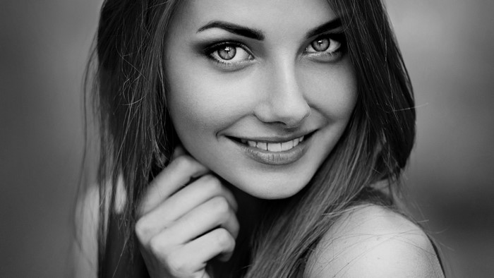 Monochrome portrait of a smiling woman with long hair