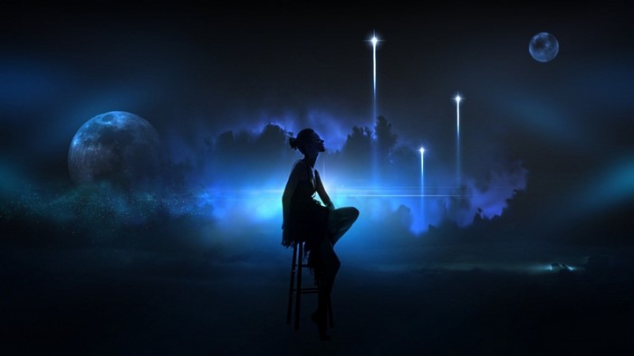Silhouette of a woman sitting under a starry night sky with moons and light beams