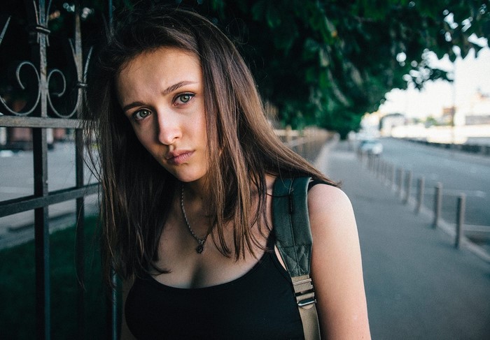 Woman with brown hair wearing a black tank top
