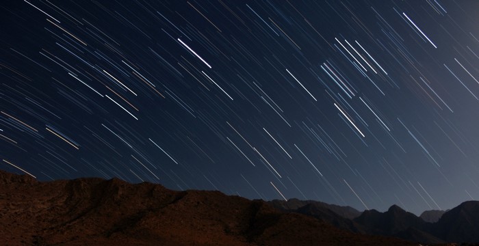 Star trails over mountains at night