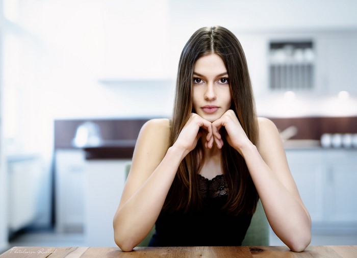 Woman with long brown hair sitting at a table
