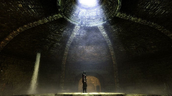 A lone figure stands in a circular stone chamber with a waterfall and sunlight from above.