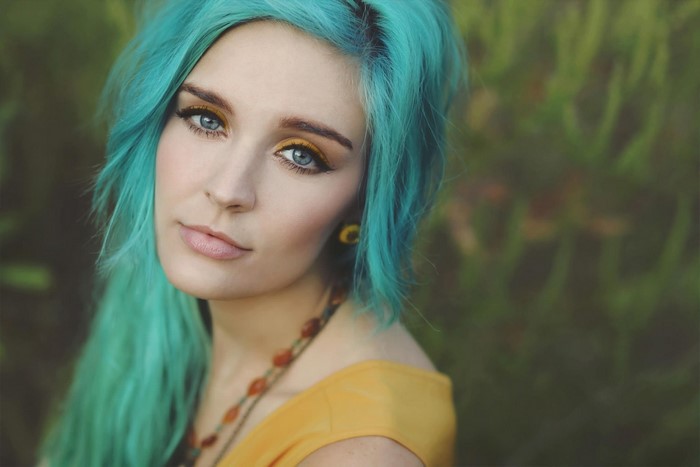 Woman with turquoise dyed hair and yellow top
