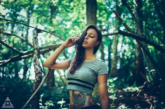 Woman with tattoos in a forest