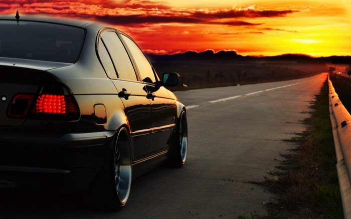 Black BMW E46 Sedan on a road at sunset