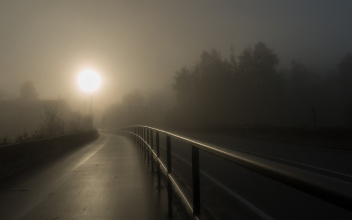 Foggy morning with sun over a bridge and road