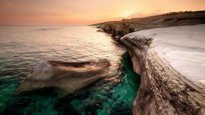 Coastal cliffs at sunset with turquoise water
