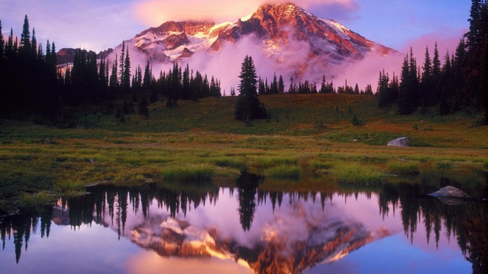 Mountain reflection in a calm lake at sunrise