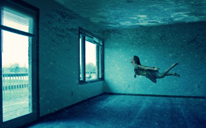Surreal underwater room with a girl swimming
