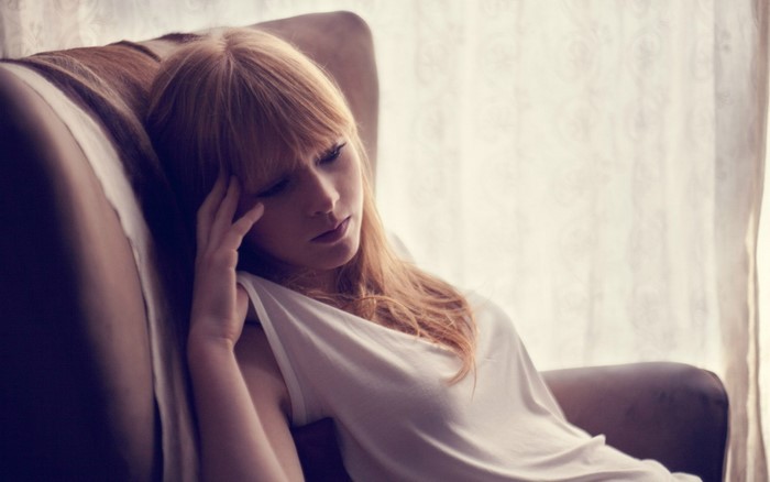 Pensive Redhead Woman Reclining on Sofa