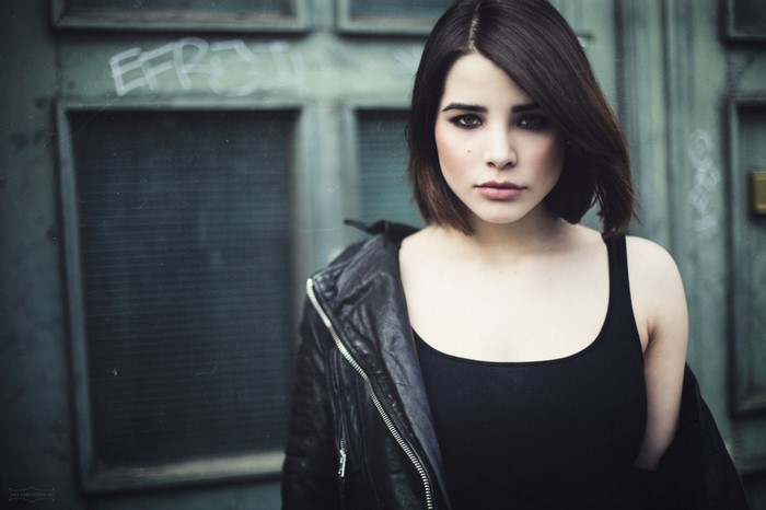 Woman with short brown hair wearing a leather jacket