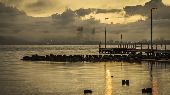 Cityscape with pier at sunset over the water