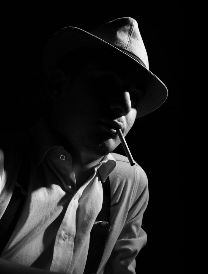 Man in fedora smoking cigarette, black and white