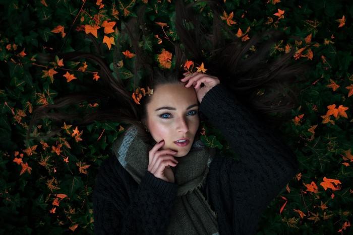 Woman lying down in autumn leaves