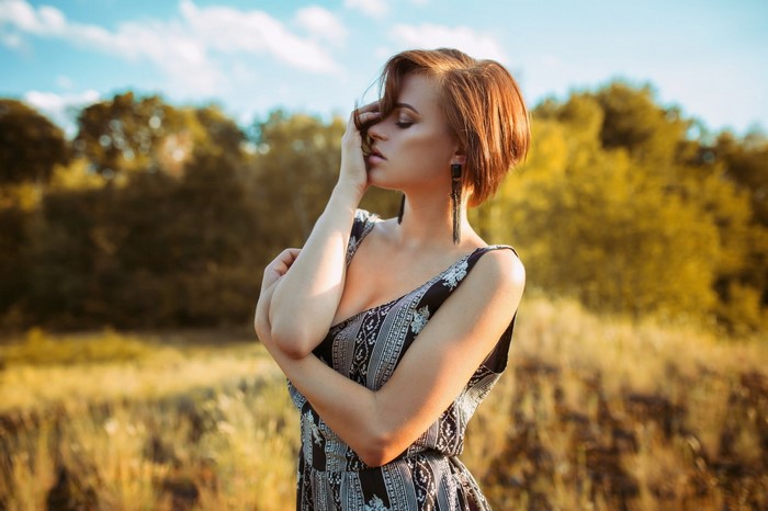 Woman with short hair in a patterned dress outdoors