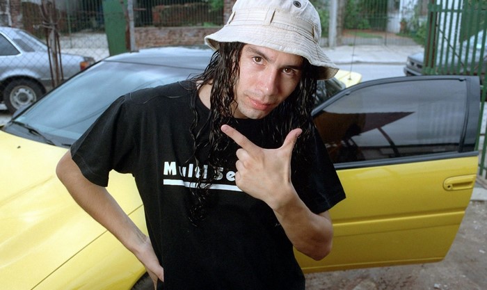 Man with long hair and bucket hat pointing