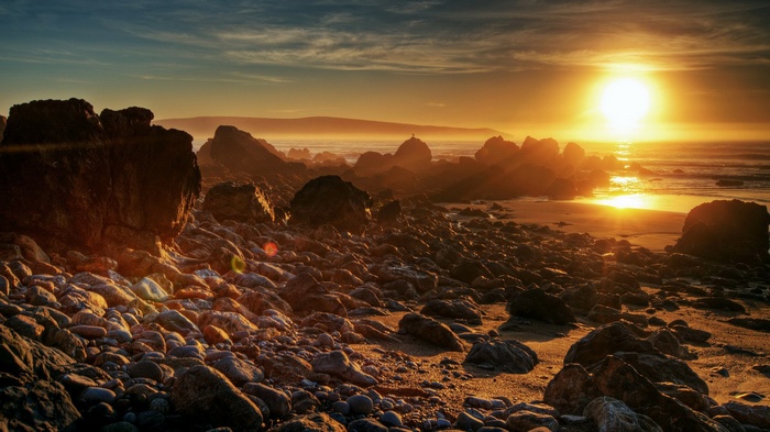 Rocky beach at sunset with ocean waves