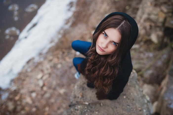 Woman with blue eyes wearing a black hoodie