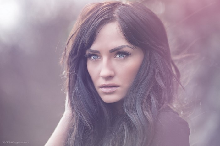 Portrait of a woman with long dark hair and blue eyes