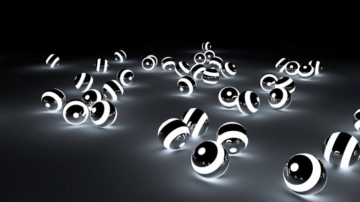 Black and white striped glowing spheres on dark surface
