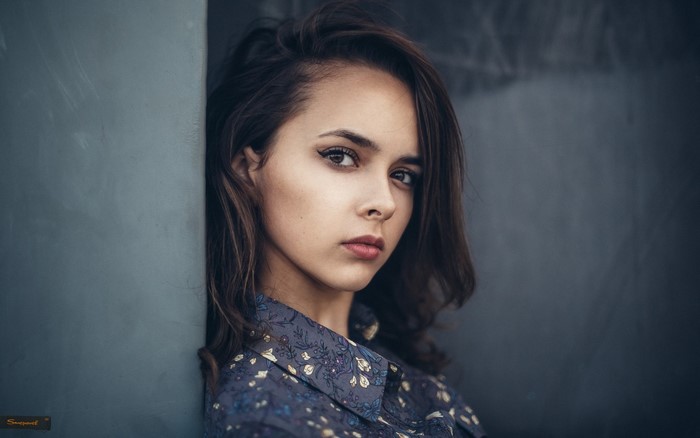 Woman with brown hair in a floral shirt