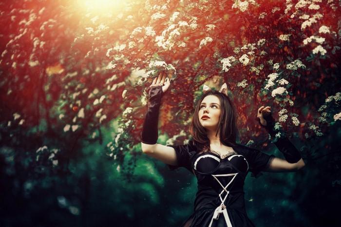 Woman in black dress with cat ears in a garden
