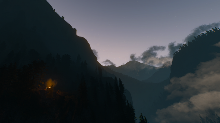 Campfire in a misty mountain valley at dawn