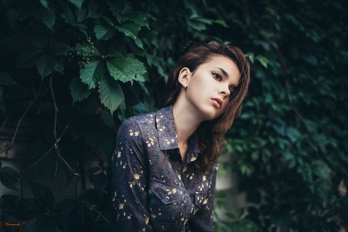 Woman with brunette hair in a floral shirt outdoors