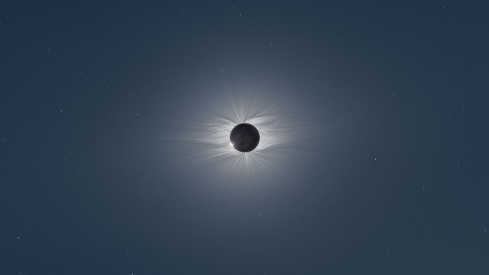 Solar eclipse with corona and stars