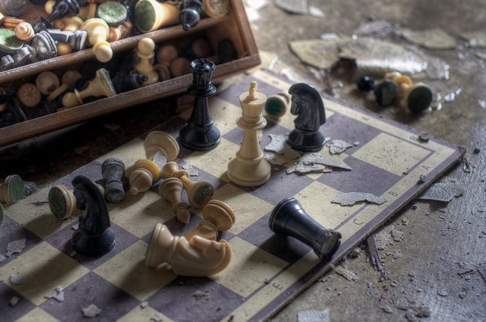 Abandoned chess set on a damaged board