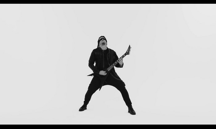 Man playing a V-shaped guitar in black and white