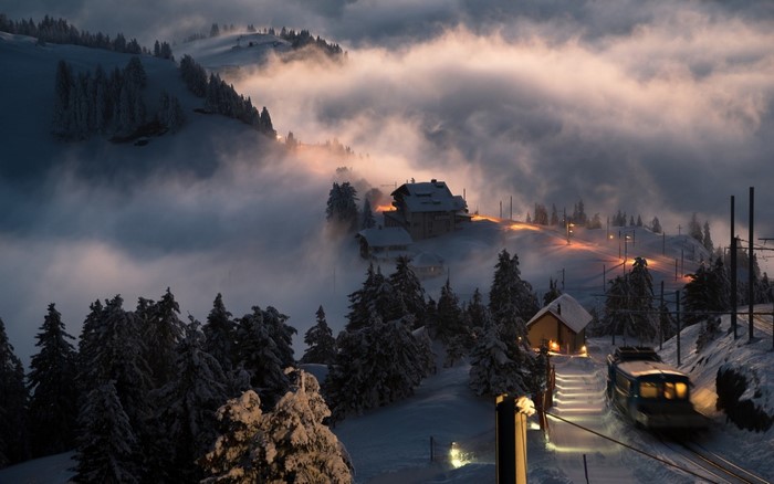 Misty Winter Evening with Train in Swiss Mountains
