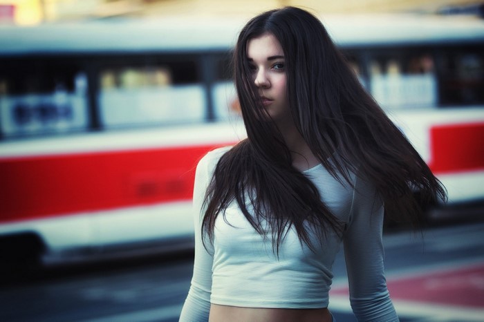 Woman with long dark hair in a white top outdoors