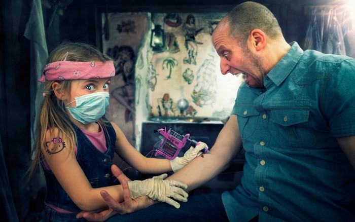 Girl tattooing man with Hello Kitty tattoo