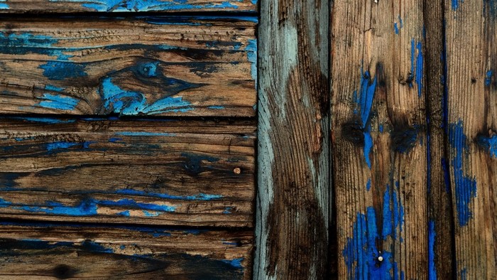 Weathered wood planks with peeling blue paint texture