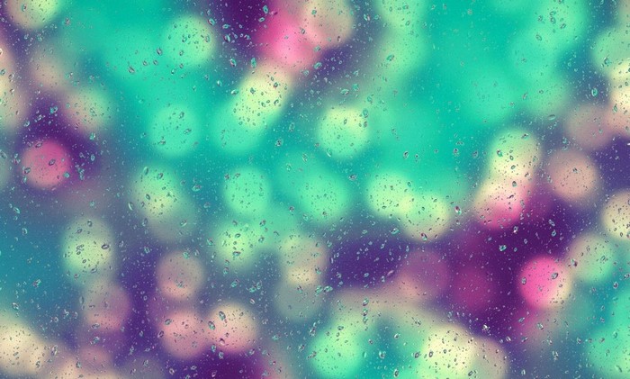 Raindrops on glass with colorful bokeh lights