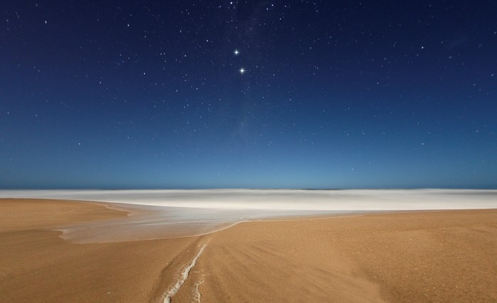 Beach at night with stars and ocean