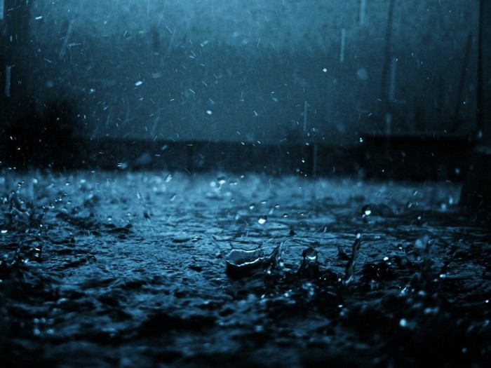Rain falling on a dark, wet surface