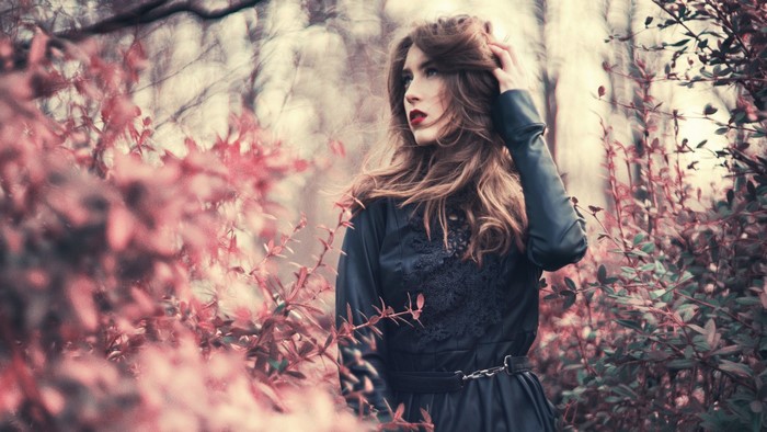 Woman in black dress with red leaves