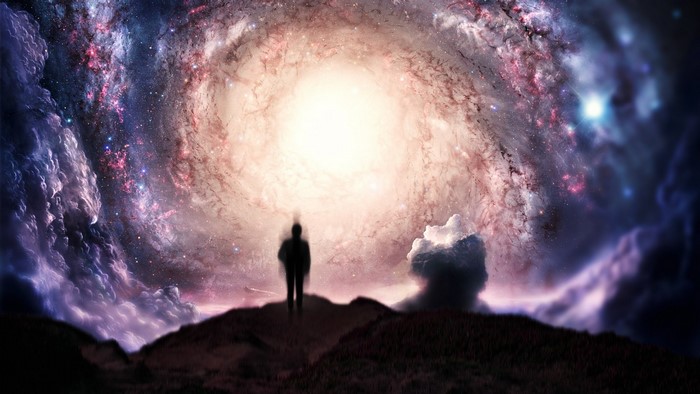 Silhouette of a person in front of a swirling galaxy