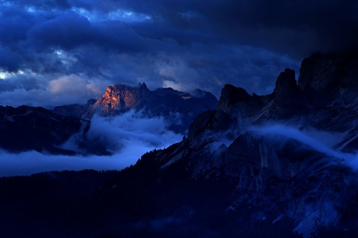 Dolomites mountains at dawn with clouds and mist